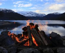 Bål ved Eimhjellvatnet med snøkledde fjell i bakgrunnen